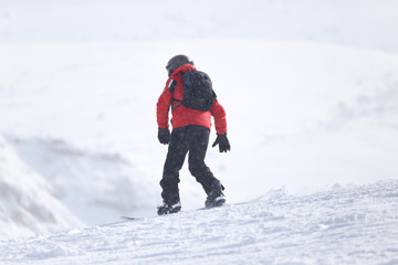 Fototapeta na wymiar Snowboarding man at flattened piste - slope