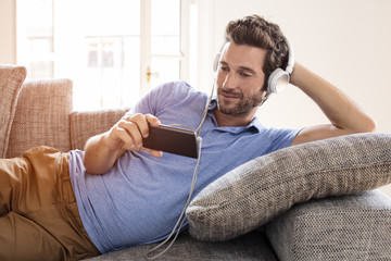 Man at home watches a movie on cell phone