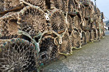 Group of old wooden lobster traps stacked on wharf