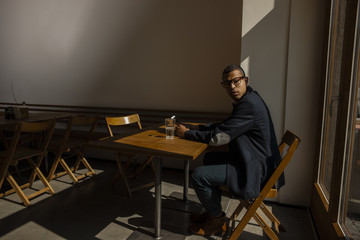 Young man sitting in cafe, waiting for someone