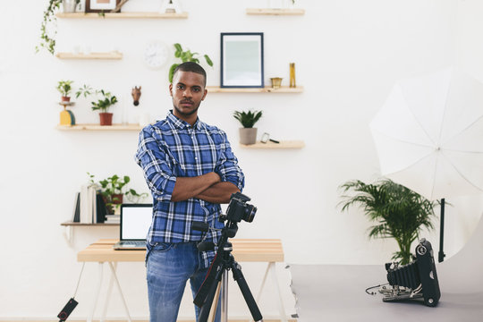 Portrait of young man standing in his photographic studio