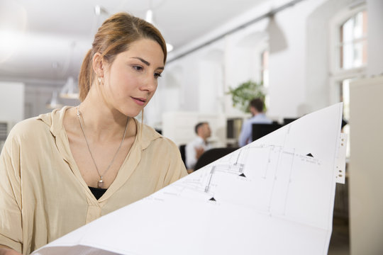 Woman in office looking at plan