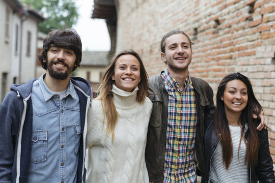 Italy, San Gimignano, group picture of four friends exploring the city
