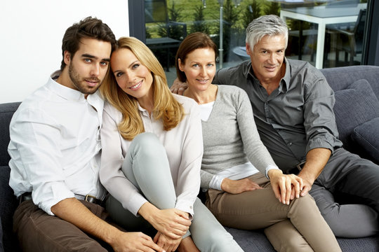 Portrait of two couples sitting together on a couch