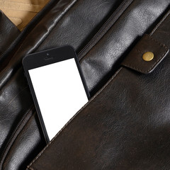 mobile phone lying on a leather bag