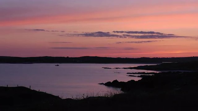 Pink sky over the Atlantic Ocean from Clifden Bay, Ireland, in the evening. 4K time lapse.