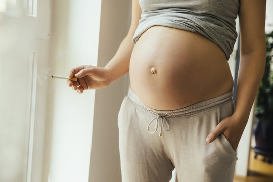 Pregnant woman holding a cigarette