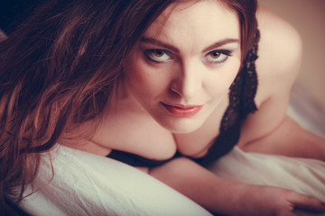 Portrait seductive young woman in lingerie in bed.