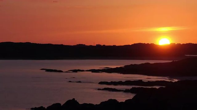 Red sun sets over the Atlantic Ocean.  4K time-lapse.