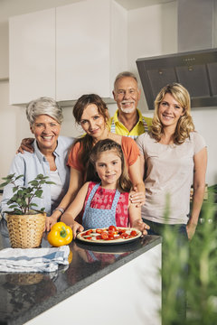 Group picture of three generations family in the kitchen