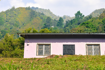 Fototapeta na wymiar Typical local house surrounded by the landscapes of Taulabe and Cerro Azul national park near Lake de Yojoa, Western Honduras