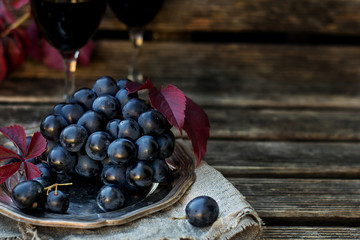Black table grapes on plate with black wine