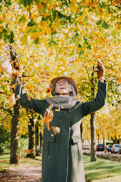 Woman throwing autumn leaves in the air