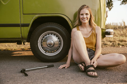 Smiling woman sitting next to a torque wrench at van