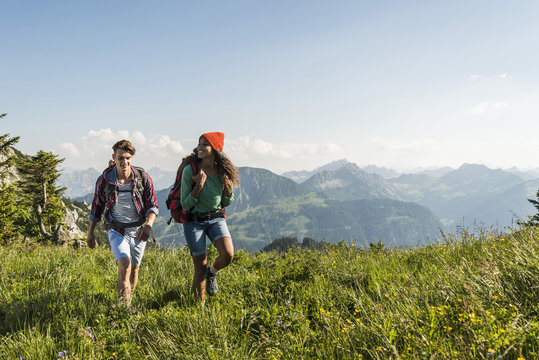 Austria, Tyrol, Tannheimer Tal, young couple hiking on alpine meadow
