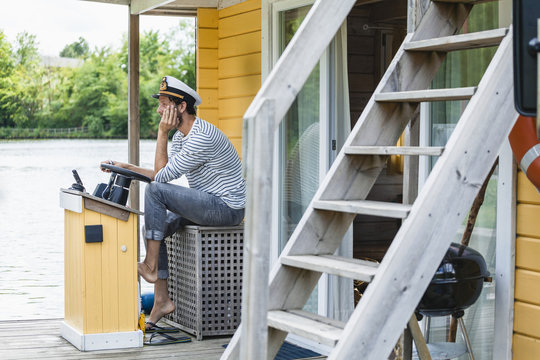 Man wearing captain's hat having a trip on a house boat