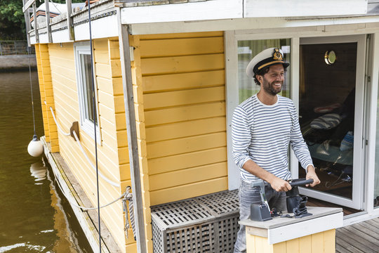 Man wearing captain's hat having a trip on a house boat