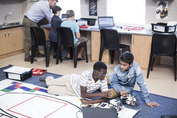 Schoolboys in robotics class testing vehicle on test track