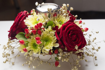 Christmas table decoration of roses, chrysanthemum and candle