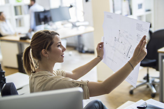 Woman in office looking at plan