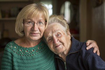 Portrait of an old woman with her adult daughter.