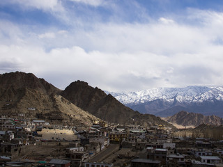 Leh town under the shadow of clouds with the snow mountain backg