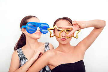 Naklejka premium Asian girls in the funny sunglasses. They pose, grimace and look at the camera. Hair removed. The skin is clean.