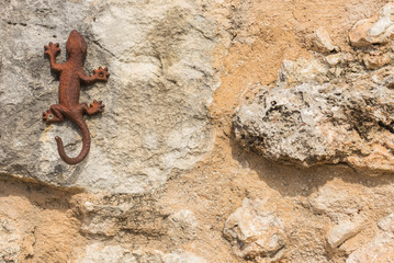Gecko Symbol auf alter Steinmauer