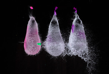 high speed photo of 3 bursting water filled balloons 