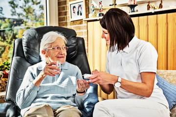 Nurse caring for elderly person at home