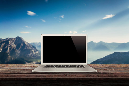 white laptop on the table with mountains in the background mockup presentation