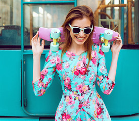 Beautiful and fashion young woman posing with a skateboard on