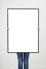 woman with  blank poster on wall background