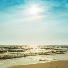 Fototapeta na wymiar sun in dramatic sky over sea with wave