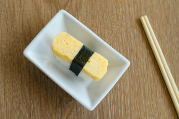 Sweet egg sushi with chopstick