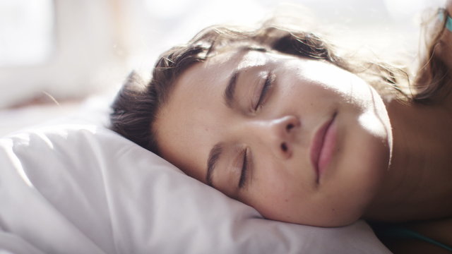 4K Attractive woman settles her head down on her pillow to rest, shot on Red Epic Dragon