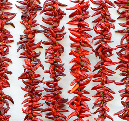 Strings of PDO Espelette chilli peppers drying