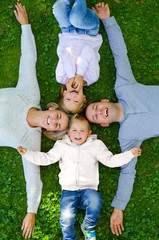Family lying on the grass and smiling