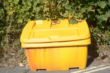Yellow grit box besides road on steep hill