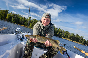 Man with autumn lake pike