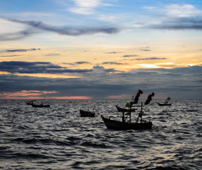 Dramatic sunset sky on the sea with fishing boat