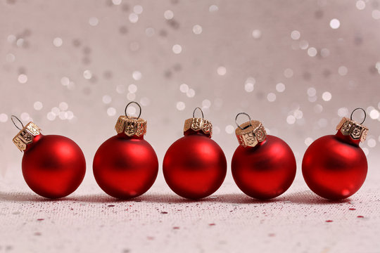 Vijf rode kerstballen met glitters op de achtergrond
