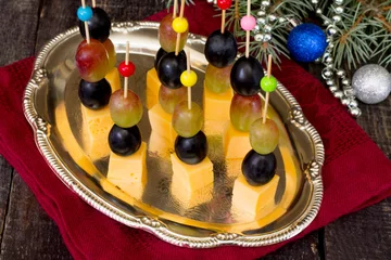 Rolgordijnen Canape with cheese and grapes on a wooden table © elena_hramowa