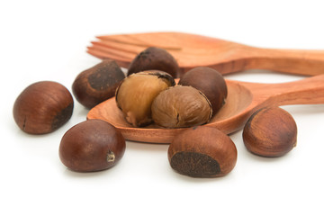 roasted chestnuts in wooden spoon on white background