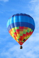 Brightly colored hot air balloon with a sky blue background