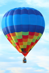 Fototapeta premium Brightly colored hot air balloon with a sky blue background