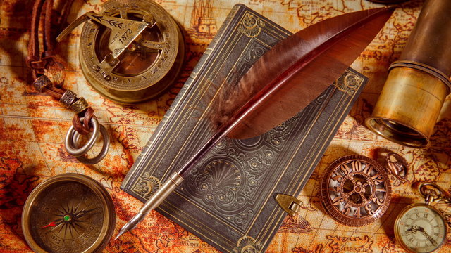 Vintage book, compass, telescope and a pocket watch lying on ancient world map in 1565.