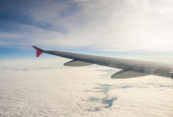Obraz premium wing airplane high above the clouds