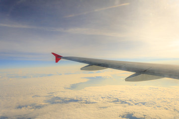 Obraz premium wing airplane high above the clouds