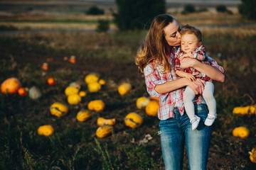 mother and daughter on a field with pumpkins